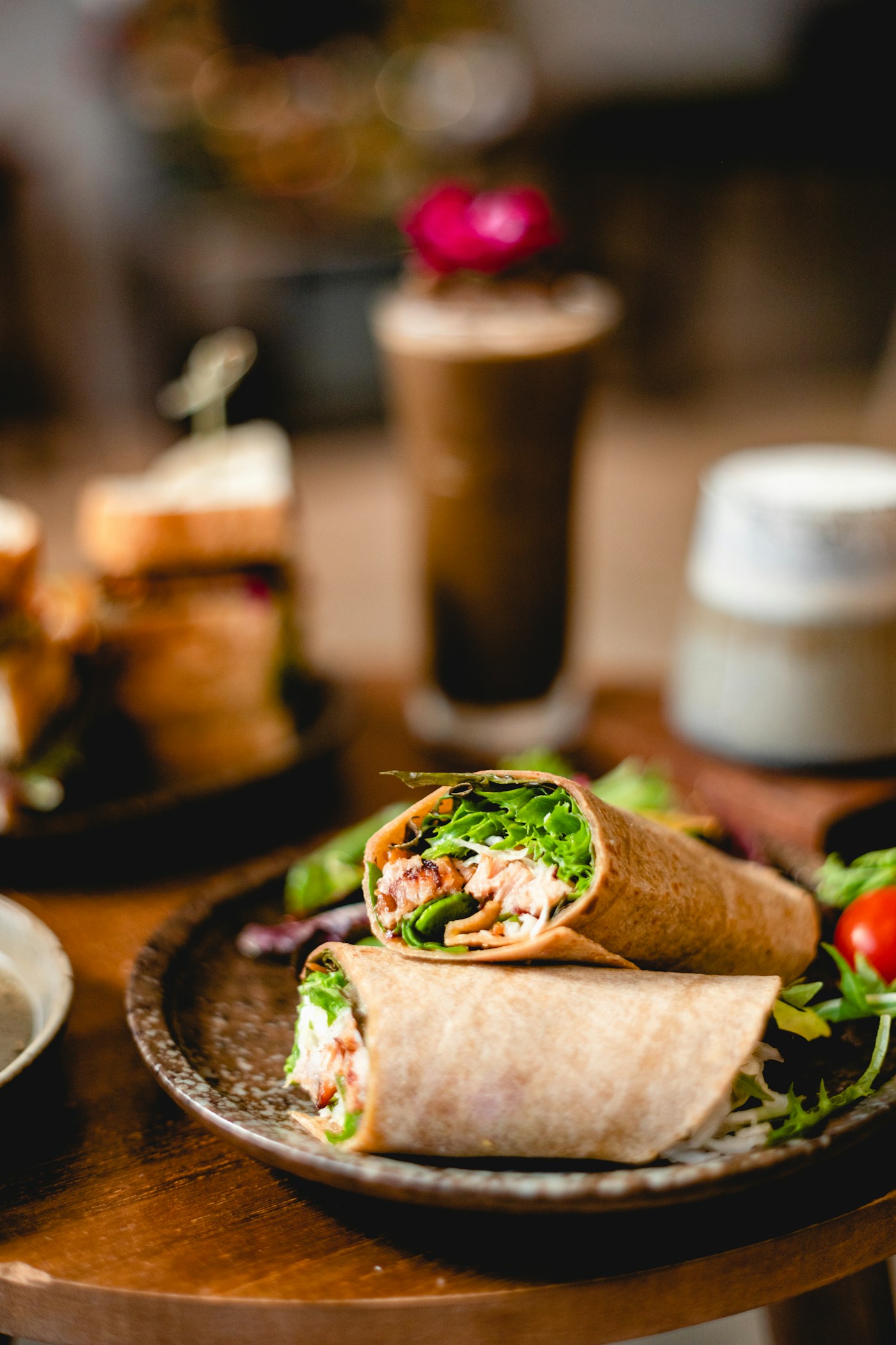 A sliced wrap served on a plate with salad