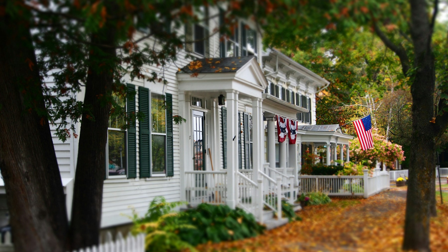 A white clapboard New England home surrounded by trees